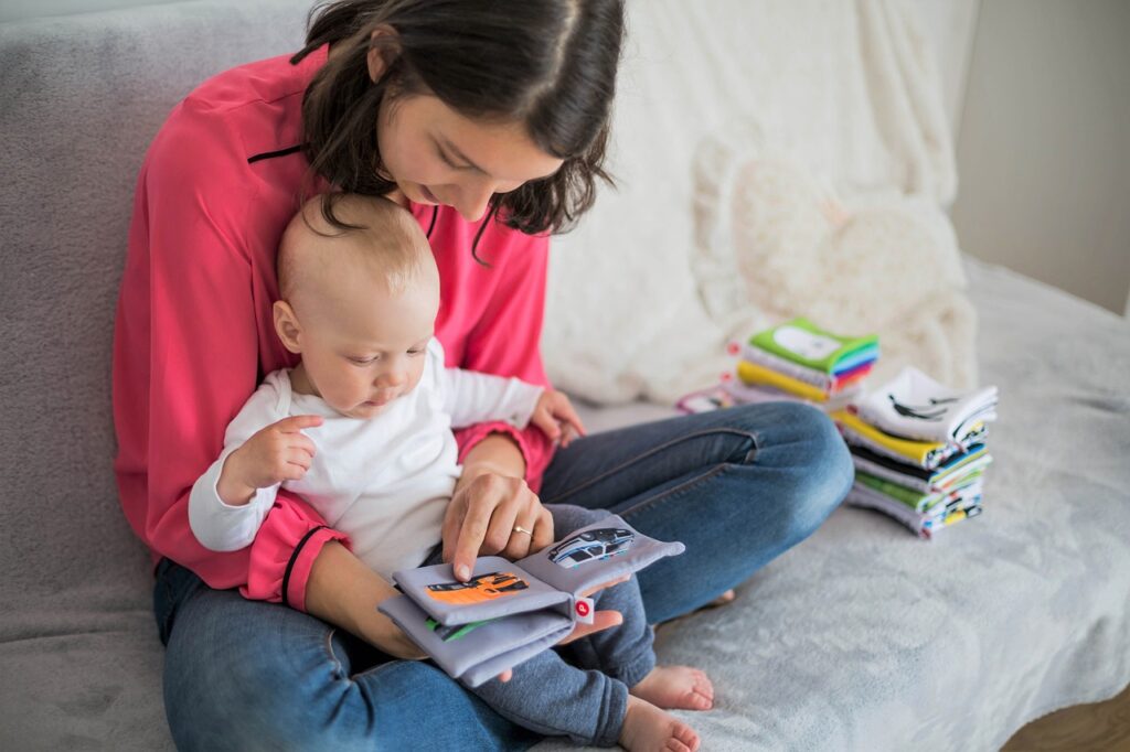 Baby is learning with his mom by colorful book